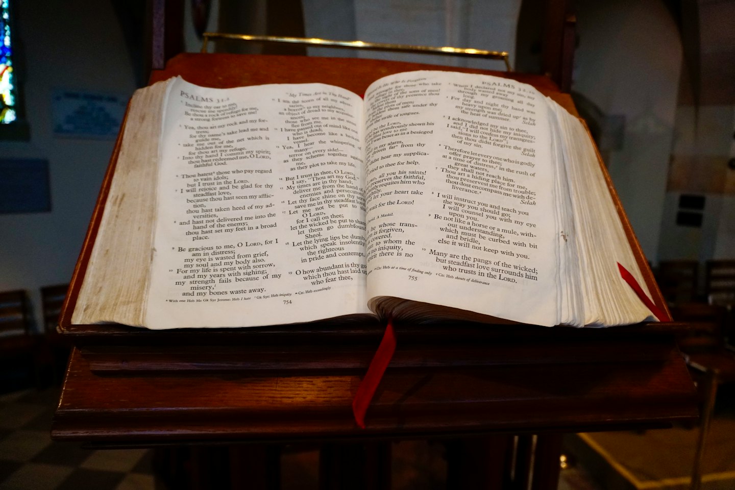 An open Bible rests on a wooden church lectern.